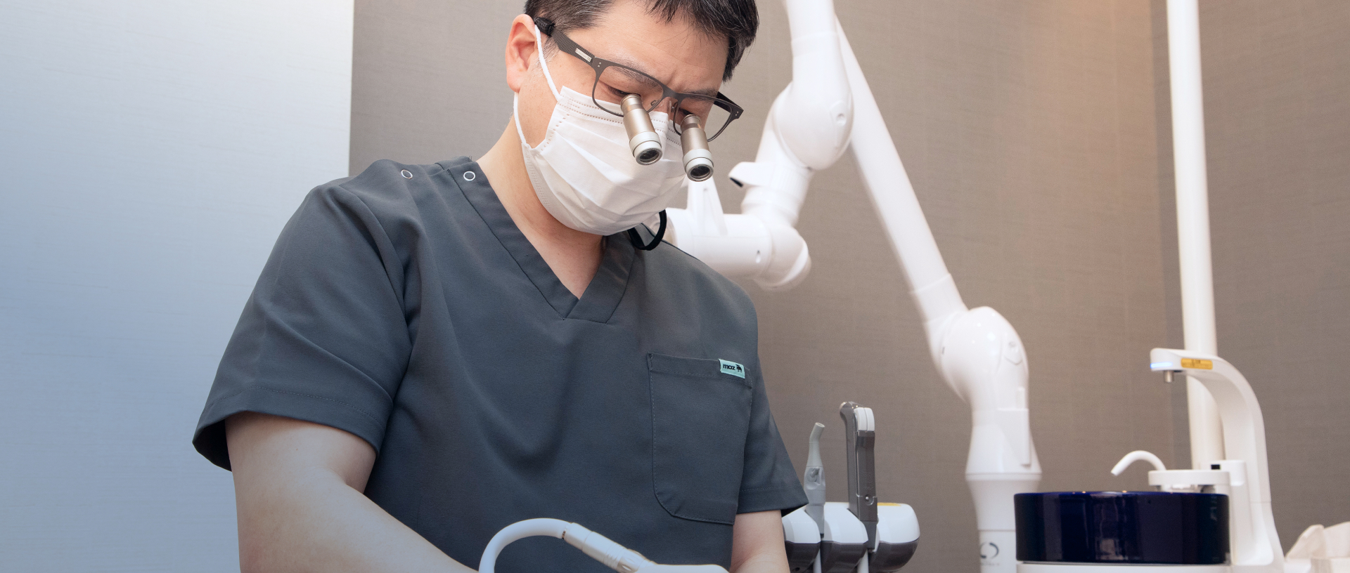 拡大鏡を着用して診療を行う歯科医師